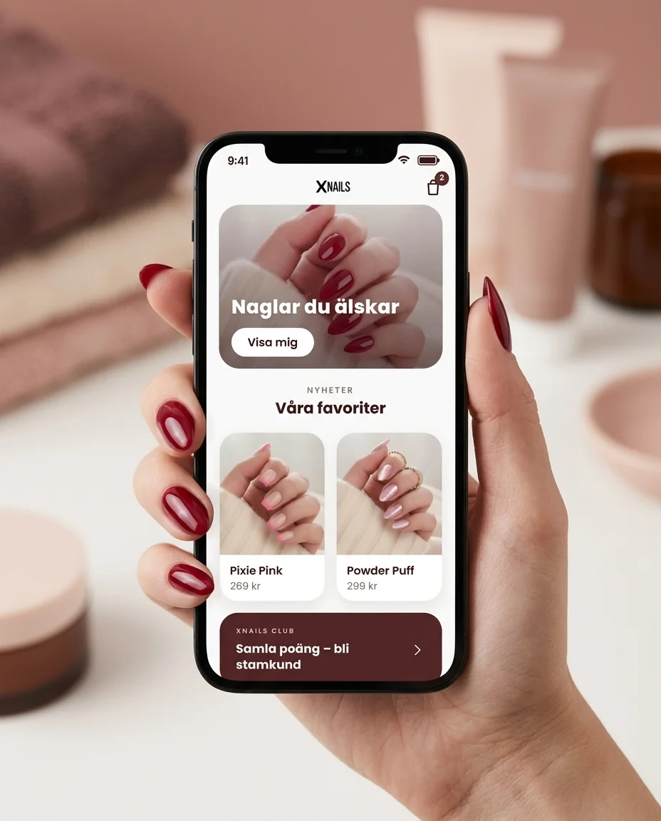 XNails-appen som visar startsidan, hållen av en hand med röda naglar